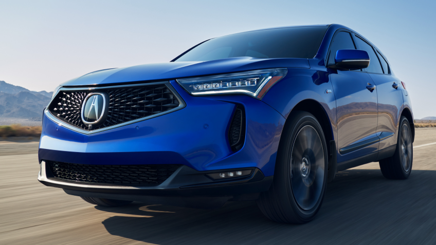 Vue 3/4 du RDX bleu sur une route désertique.