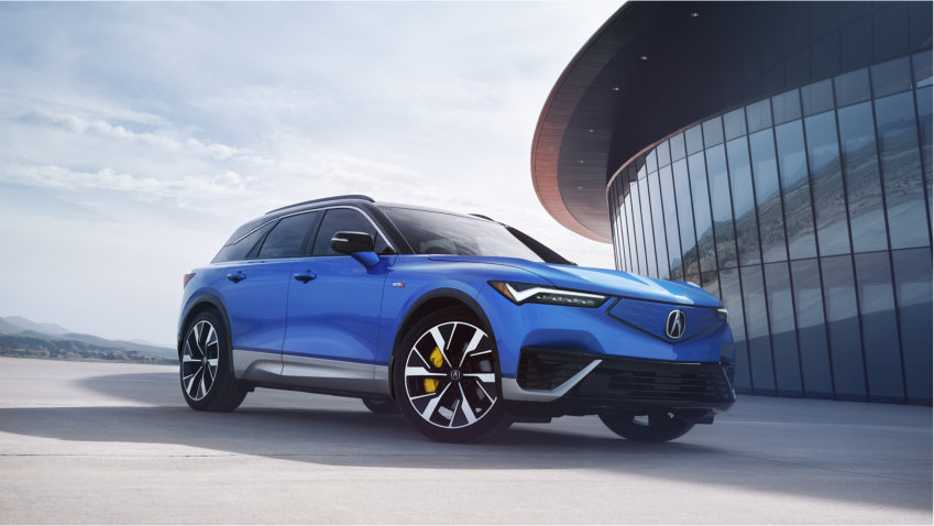 Vue 3/4 avant du ZDX bleu stationné à l'extérieur d'un bâtiment moderne en verre au coucher du soleil.