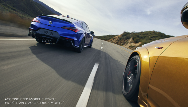 Plan de trois quarts arrière d’une Integra Type S bleue roulant sur une autoroute aux côtés d’une Integra Type S de couleur or.