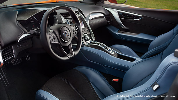 Interior front cabin in an Acura NSX featuring blue and black leather seating.	Habitacle avant d’une Acura NSX avec sièges en cuir bleu et noir.